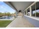 An inviting covered back patio featuring a built-in TV, and a beautiful pool surrounded by lush greenery at 2923 E Preston St, Mesa, AZ 85213