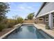 Backyard pool with water feature is surrounded by travertine and landscaping at 2923 E Preston St, Mesa, AZ 85213