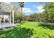 Lush backyard with manicured lawn, covered patio and separate fire pit area for outdoor entertaining and relaxation at 348 W Portland St, Phoenix, AZ 85003