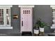 Close-up of a charming pink front door with a decorative mail slot and potted plants adding a touch of elegance and curb appeal at 348 W Portland St, Phoenix, AZ 85003