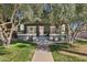 Attractive home featuring a gray exterior, a pink front door, a well-kept lawn, and mature trees providing ample shade at 348 W Portland St, Phoenix, AZ 85003