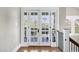 Light filled hallway with hardwood floors leads to the outside patio through bright french doors at 348 W Portland St, Phoenix, AZ 85003