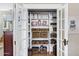 Organized pantry with shelving and baskets inside bright white french doors, perfect for storage at 348 W Portland St, Phoenix, AZ 85003