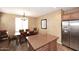 Bright dining area adjacent to the kitchen with stylish lighting fixture and window at 3685 N 162Nd Ln, Goodyear, AZ 85395