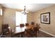 Formal dining room featuring a large wooden table with seating for six under modern lighting at 3685 N 162Nd Ln, Goodyear, AZ 85395