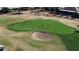 Overhead view of a golf course featuring a green, sand trap, and golfers on a sunny day at 3685 N 162Nd Ln, Goodyear, AZ 85395