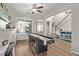 Open-concept game room featuring wood floors, a ceiling fan, and views of the staircase and foyer at 3851 E Vallejo Dr, Gilbert, AZ 85298