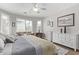 Bright main bedroom featuring a sitting area, ceiling fan, wood floors, and lots of light at 3851 E Vallejo Dr, Gilbert, AZ 85298