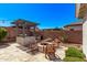 Outdoor kitchen with a built-in grill, fire pit and seating area perfect for outdoor entertaining at 3851 E Vallejo Dr, Gilbert, AZ 85298