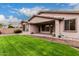 Sprawling backyard featuring a lush green lawn, brick-paved patio, and mature landscaping elements at 3881 S Marion Way, Chandler, AZ 85286