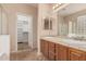 Bathroom featuring dual sinks, tiled countertops, and access to a spacious walk-in closet at 3881 S Marion Way, Chandler, AZ 85286