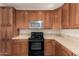 Cozy kitchen with stainless steel microwave, oven, and rich wood cabinets at 3881 S Marion Way, Chandler, AZ 85286