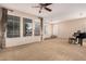 Bright living room featuring large windows, plush carpeting, and a ceiling fan at 3881 S Marion Way, Chandler, AZ 85286