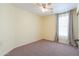 Neutral bedroom featuring carpeted floors, a ceiling fan, and a window with bright natural light at 40401 W Hayden Dr, Maricopa, AZ 85138