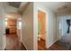 Hallway view showcasing wood floors and leading to the kitchen and bathroom at 40401 W Hayden Dr, Maricopa, AZ 85138