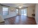 Bright living room with wood floors and large windows and sliding doors to the patio at 40401 W Hayden Dr, Maricopa, AZ 85138