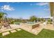 A backyard oasis with a pool, spa, manicured turf, desert landscaping, and cozy swing offers ultimate relaxation at 4319 W Winslow Way, Eloy, AZ 85131