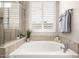 Bright bathroom with a white soaking tub, shutters on the window, and tile surround at 4319 W Winslow Way, Eloy, AZ 85131