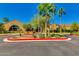 The Ranch House entrance sign is nestled among mature landscaping and stately palm trees, creating a grand community entrance at 4319 W Winslow Way, Eloy, AZ 85131