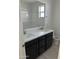 Contemporary bathroom showcasing a double vanity with dark cabinetry and a white countertop, complemented by a framed mirror at 43387 N Wollemi St, Queen Creek, AZ 85140