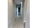 A long hallway with light wood-look flooring, neutral paint and access to the kitchen at 43387 N Wollemi St, Queen Creek, AZ 85140