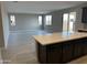 Open-concept living area with tiled flooring and a center island bar connecting to the kitchen at 43387 N Wollemi St, Queen Creek, AZ 85140