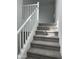 Carpeted staircase leading to the second floor, featuring white railings and neutral walls at 43387 N Wollemi St, Queen Creek, AZ 85140