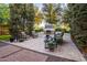 Cozy backyard featuring an outdoor fireplace, comfortable seating, lush greenery, and manicured landscaping at 4376 S Santiago Way, Chandler, AZ 85248