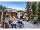 Relaxing backyard featuring a covered patio, travertine pavers, a seating area, and lush landscaping at 4376 S Santiago Way, Chandler, AZ 85248