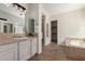 Bathroom featuring dual sinks, a walk-in closet, a soaking tub, and tile flooring at 4376 S Santiago Way, Chandler, AZ 85248