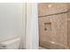 A bathroom shower and tub combination featuring neutral tiling, inset shelf and toilet at 4376 S Santiago Way, Chandler, AZ 85248