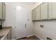 Laundry room with sage green cabinets, tile floor, and white painted door at 4376 S Santiago Way, Chandler, AZ 85248