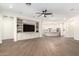 Open-concept living room with built-in shelving, ceiling fan, and hardwood floors at 4376 S Santiago Way, Chandler, AZ 85248