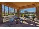 Inviting outdoor seating area with stone columns and multiple picnic tables offers a relaxing space in this community at 4376 S Santiago Way, Chandler, AZ 85248