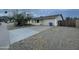 View of home's exterior features a two-car garage, mature trees, and desert landscaping at 4416 E Capistrano Ave, Phoenix, AZ 85044