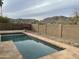 Backyard pool features tiled deck, block fence, and views of mountains in the distance at 4416 E Capistrano Ave, Phoenix, AZ 85044