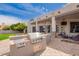 Outdoor kitchen and patio with stainless steel grill, perfect for entertaining and enjoying the spacious backyard at 4438 E Millbrae Ln, Gilbert, AZ 85234