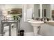 Well-lit bathroom features a pedestal sink, framed mirror, and decorative accents at 4438 E Millbrae Ln, Gilbert, AZ 85234