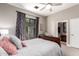 Cozy bedroom has a ceiling fan, dark wood furniture, and an ensuite bathroom at 4438 E Millbrae Ln, Gilbert, AZ 85234