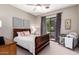 Cozy bedroom boasts a ceiling fan, dark wood furniture, and sliding glass door to the backyard at 4438 E Millbrae Ln, Gilbert, AZ 85234