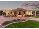 Inviting single-story home featuring stone accents, desert landscaping, and a circular driveway at 4438 E Millbrae Ln, Gilbert, AZ 85234