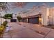 Attached three-car garage with gray doors, stone accents and an expansive driveway at 4438 E Millbrae Ln, Gilbert, AZ 85234