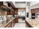 Modern kitchen featuring stainless steel appliances, granite countertops, and dark wood cabinetry, ideal for cooking at 4438 E Millbrae Ln, Gilbert, AZ 85234