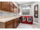 Laundry room features ample cabinet space and modern red washer and dryer units at 4438 E Millbrae Ln, Gilbert, AZ 85234