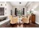 Sunlit living room featuring wicker chairs, a decorative chandelier, and dark hardwood flooring at 4438 E Millbrae Ln, Gilbert, AZ 85234