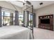 Spacious primary bedroom featuring a canopy bed, large windows with backyard views, and entertainment center at 4438 E Millbrae Ln, Gilbert, AZ 85234