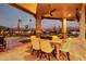 Covered outdoor dining space features a wooden table with six chairs and views of the pool and landscaped yard at 4438 E Millbrae Ln, Gilbert, AZ 85234