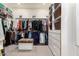 Large walk-in closet with custom shelving, hanging rods, drawers and central ottoman at 4438 E Millbrae Ln, Gilbert, AZ 85234