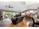 Open-concept living room featuring hardwood floors, comfortable leather seating, and a large sliding glass door at 4444 W Chama Dr, Glendale, AZ 85310