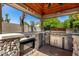 Custom outdoor kitchen boasts stone accents, built-in grill, and covered patio for ultimate entertainment at 4444 W Chama Dr, Glendale, AZ 85310